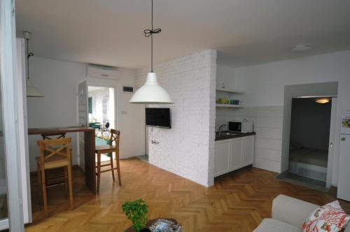 uma sala de estar e cozinha com uma parede de tijolos brancos em Villa Allegra em Lovran