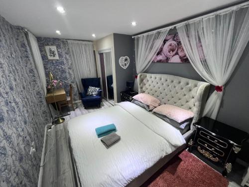 - une chambre avec un grand lit blanc et des oreillers roses dans l'établissement Rooms near Canary wharf, à Londres