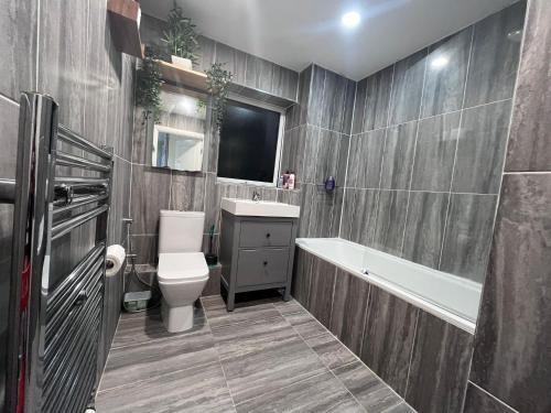 La salle de bains est pourvue de toilettes, d'une baignoire et d'un lavabo. dans l'établissement Rooms near Canary wharf, à Londres