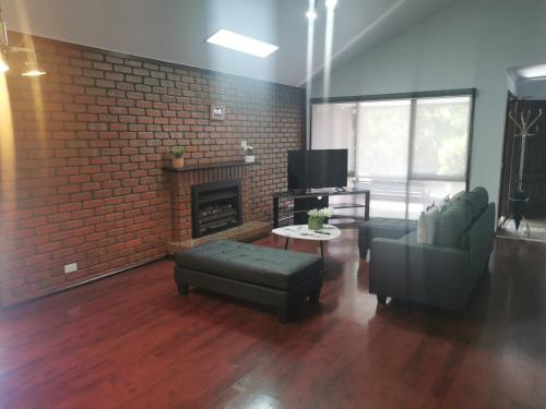 a living room with a couch and a fireplace at Peaceful House In Mill Park Melbourne in Mill Park