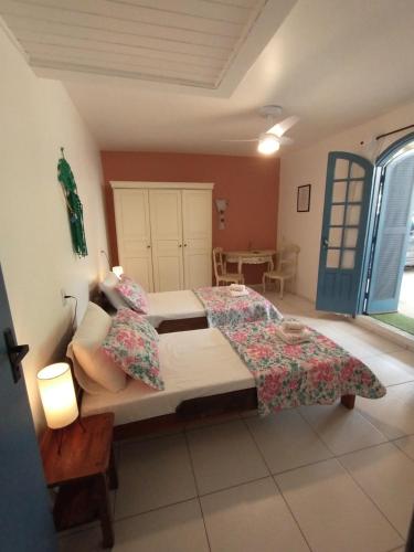 a bedroom with a bed and a table and a window at Areias do Sol Suítes in Florianópolis