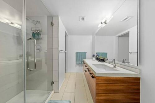 y baño blanco con lavabo y ducha. en Blue Horizons 2BR Water Front Full Marina View, en Los Ángeles