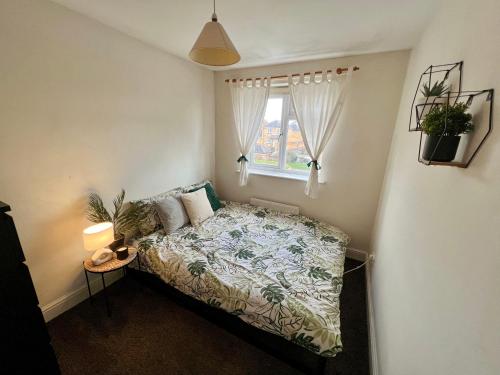 a small bedroom with a bed and a window at Entire 3 bedroom end of terrace house! in Thamesmead