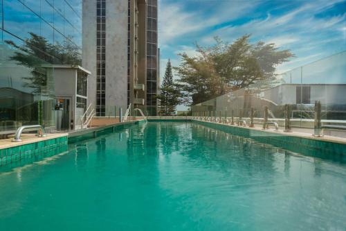 uma grande piscina de água azul em frente a um edifício em Tryp by Wyndham Brasília Nações em Brasília