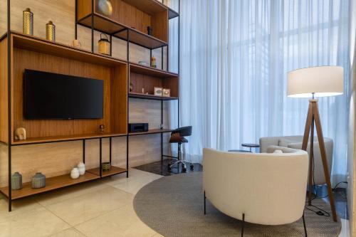 巴西利亞的住宿－Tryp by Wyndham Brasília Nações，一间带电视和椅子的客厅