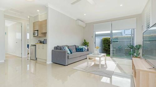 a living room with a couch and a table at Cabarita Reef House - Pool, Lake, Beach & AC! in Cabarita Beach