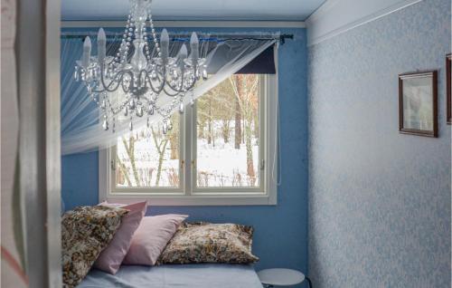 a chandelier hanging over a bed in a room with a window at 2 Bedroom Gorgeous Home In Linkping in Linköping