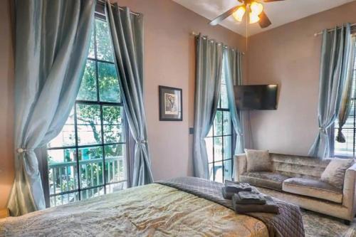 a bedroom with a bed and a couch and windows at 1234 New Orleans in New Orleans