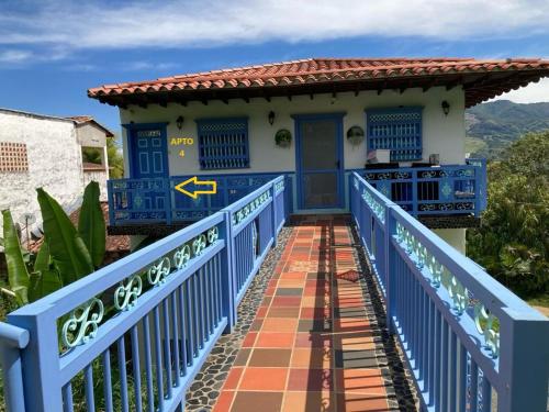 un puente azul que conduce a una casa con una puerta azul en Apartahotel Villa Carolina 4, en Jericó
