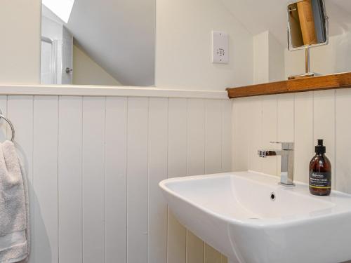 een witte badkamer met een wastafel en een spiegel bij Pride Of Erin - Uk45929 in Linlithgow