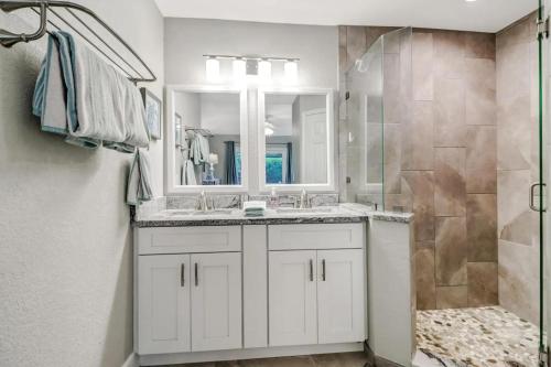 マルコ・アイランドにあるStunning 4BR Beach House - Pool - Spa - Near the Parkの洗面台とシャワー付きの白いバスルーム