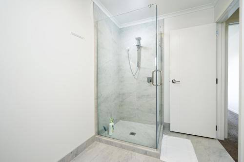 y baño con ducha y puerta de cristal. en Stunning 3 bedrooms house in Hillcrest - Close to Waikato University & Cambridge, en Hamilton