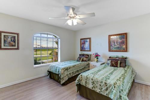 a bedroom with two beds and a ceiling fan at 1395 Marco Island in Marco Island