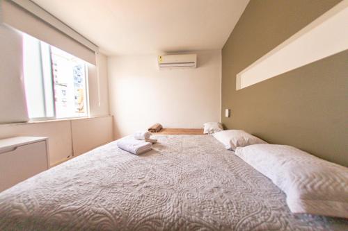 ein Schlafzimmer mit einem großen Bett mit zwei Kissen darauf in der Unterkunft Duplex Ipanema Vinícius de Moraes in Rio de Janeiro
