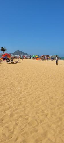 a sandy beach with people flying kites on it at Maravilhosa Kitnet 10 min da praia in Vila Velha