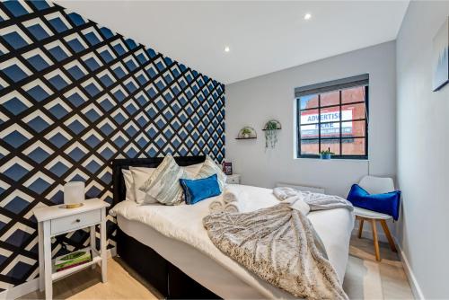 a bedroom with a bed and a geometric wall at Bright and Relaxing One Bedroom Flat in London