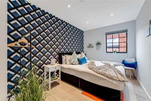 a bedroom with a bed and a black and white wall at Bright and Relaxing One Bedroom Flat in London