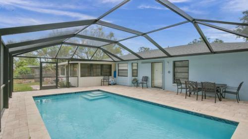 una piscina con tetto in vetro e un patio con tavolo e sedie di 6795 Sarasota a Sarasota