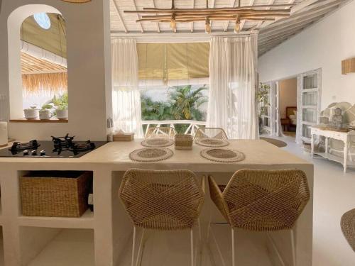 eine Küche mit einer Insel mit einem Herd und Stühlen in der Unterkunft Mediterranean 2Bdr Villa near Pererenan Beach in Canggu