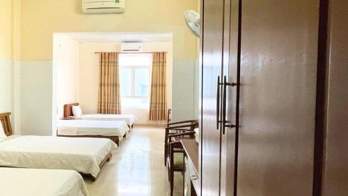 Habitación hospitalaria con 3 camas y ventana en Khách sạn 206 en Da Nang