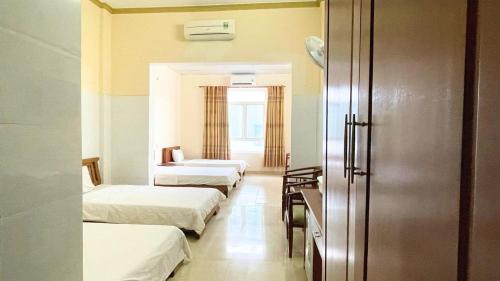 Habitación de hotel con 3 camas y ventana en Khách sạn 206 en Da Nang