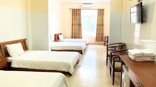 Habitación de hotel con 3 camas y lavamanos en Khách sạn 206, en Da Nang