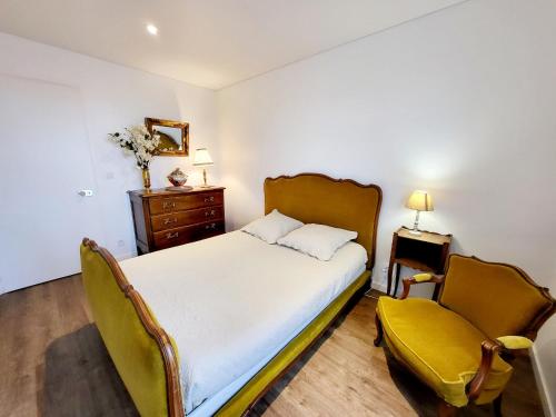 een slaapkamer met een bed en een gele stoel bij Appartement Les Sables-d'Olonne, 3 pièces, 6 personnes - FR-1-92-765 in Les Sables-dʼOlonne