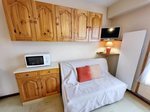 - un salon avec une chaise et un four micro-ondes dans l'établissement Studio charmant proche plage, chenal, et commerce, bien équipé au cœur des Sables d'Olonne - FR-1-92-597, à Les Sables-dʼOlonne