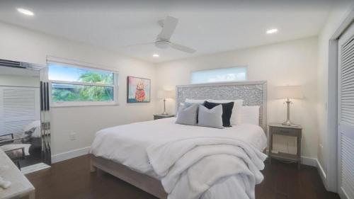 een witte slaapkamer met een groot bed en een raam bij 7340 Sarasota in Sarasota