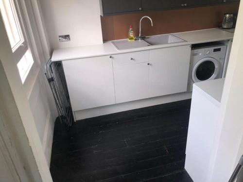 a kitchen with a sink and a washing machine at 10 Large Elegant Studio - Prime Location - Comfortable - Private in Brighton & Hove