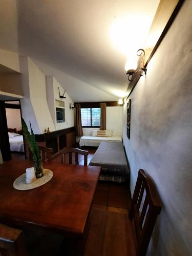 - un salon avec une table et un lit dans l'établissement Terrazas del Venado, à La Cumbre