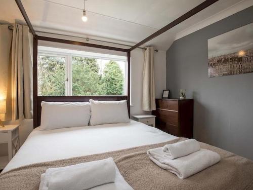 a bedroom with a large bed with two towels on it at HAVEN VALLEY in Old Windsor