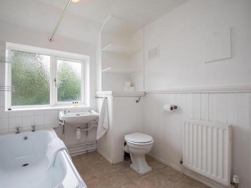 a white bathroom with a toilet and a sink at HAVEN VALLEY in Old Windsor