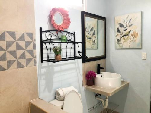 uma casa de banho com um lavatório e um WC branco em Hermosa Casa en Chelem A 5 min Caminando de Playa em Chelem