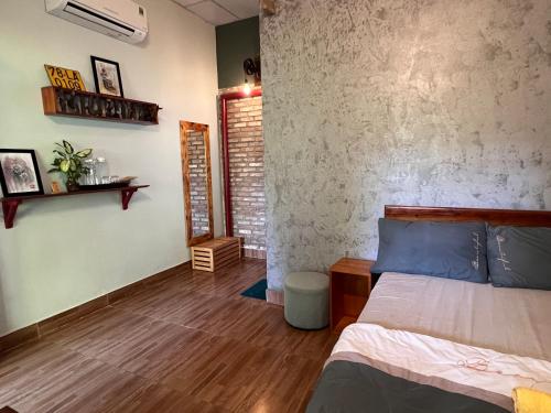 een slaapkamer met een bed en een bakstenen muur bij Trại Hoa Vàng Homestay at Tuy Hòa Phú Yên in Ðông Tác (1)