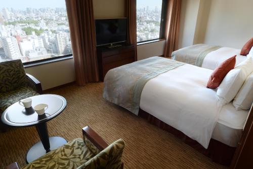 a hotel room with a bed and a tv at Hotel Metropolitan Tokyo Ikebukuro in Tokyo