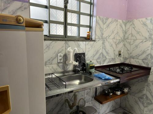 a kitchen counter with a sink and a stove at Luso Apartamentos in Manaus