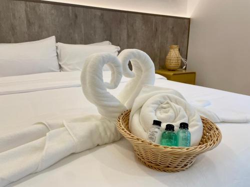 two swans towels and bottles in a basket on a bed at Nan Cozy House in Nan