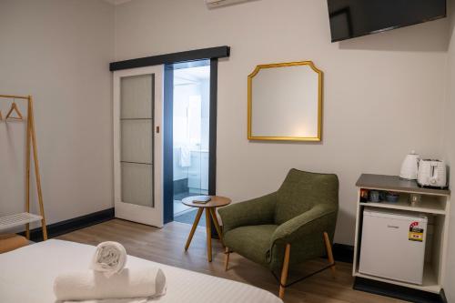 a living room with a chair and a mirror at The Rec Hotel Waroona in Waroona