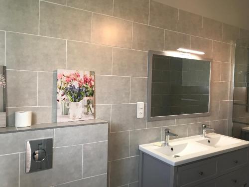 une salle de bain avec un lavabo et un miroir dans l'établissement Villa spacieuse avec terrasse en bord de mer et animaux acceptés - FR-1-22-249, à La Tranche-sur-Mer