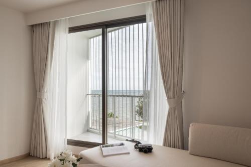 a bedroom with a large window with a view of the city at U Hua Hin in Cha Am