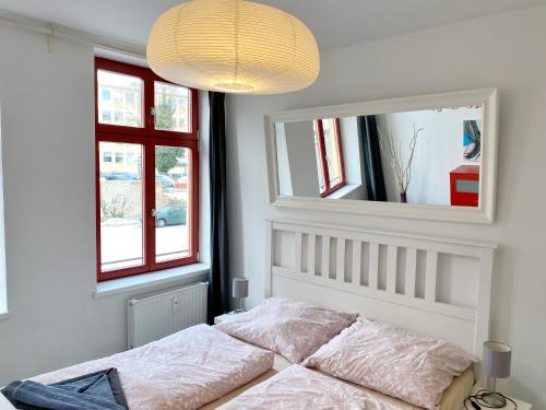 Stralsund - Haus Gohr, Quartier 1 في شترالزوند: غرفة نوم بسرير ومرآة كبيرة