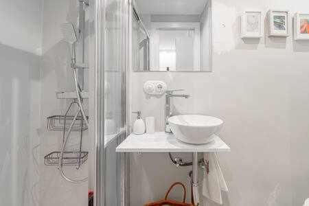 a white bathroom with a sink and a shower at Apartamento La Latina Palacio in Madrid