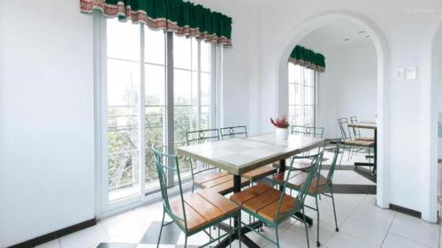 a dining room with a table and chairs and windows at New Orleans Tagaytay in Tagaytay