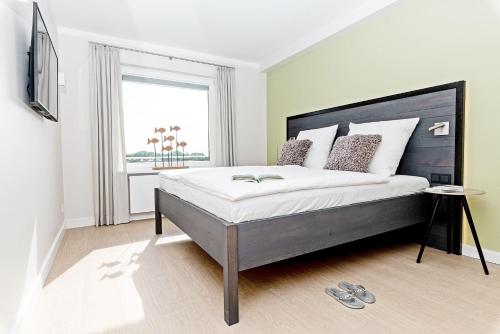 ein Schlafzimmer mit einem großen Bett und einem Fenster in der Unterkunft Haus Norderhoog Wohnung 67 - "Zoe's Nest"  in Westerland