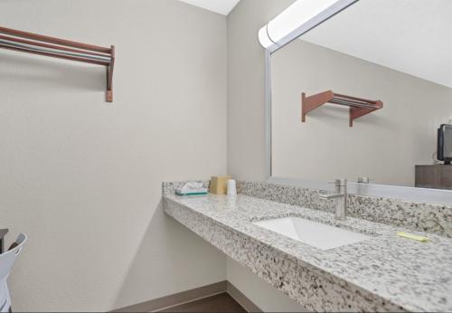 Bridgeview Inn Chicago Area في بريدجفيو: حمام مع حوض ومرآة