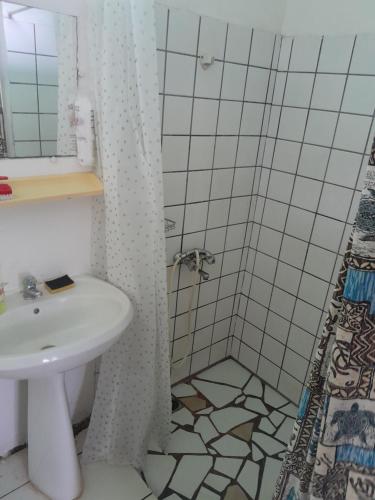 uma casa de banho com um lavatório e um chuveiro em Ravehei smile relais 2 moorea em Afareaitu