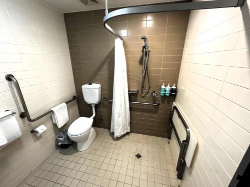 a bathroom with a toilet and a shower at Novotel Darwin Airport in Darwin