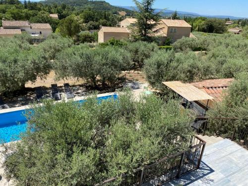 Elle offre une vue sur une cour avec des arbres et une piscine. dans l'établissement Gîte dans villa rénovée avec piscine, climatisation et WiFi à Saint-Saturnin-lès-Apt - FR-1-708-62, à Saint-Saturnin-lès-Apt