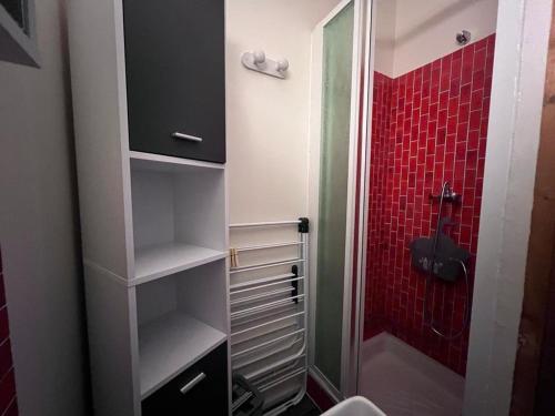 La salle de bains est pourvue d'une douche et de carrelage rouge. dans l'établissement Studio Cabine Calme avec Balcon, Proche Navette et Station Les Angles - FR-1-593-100, aux Angles